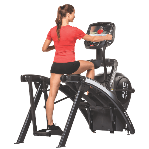 a woman using a Cybex 525 AT Arc Trainer